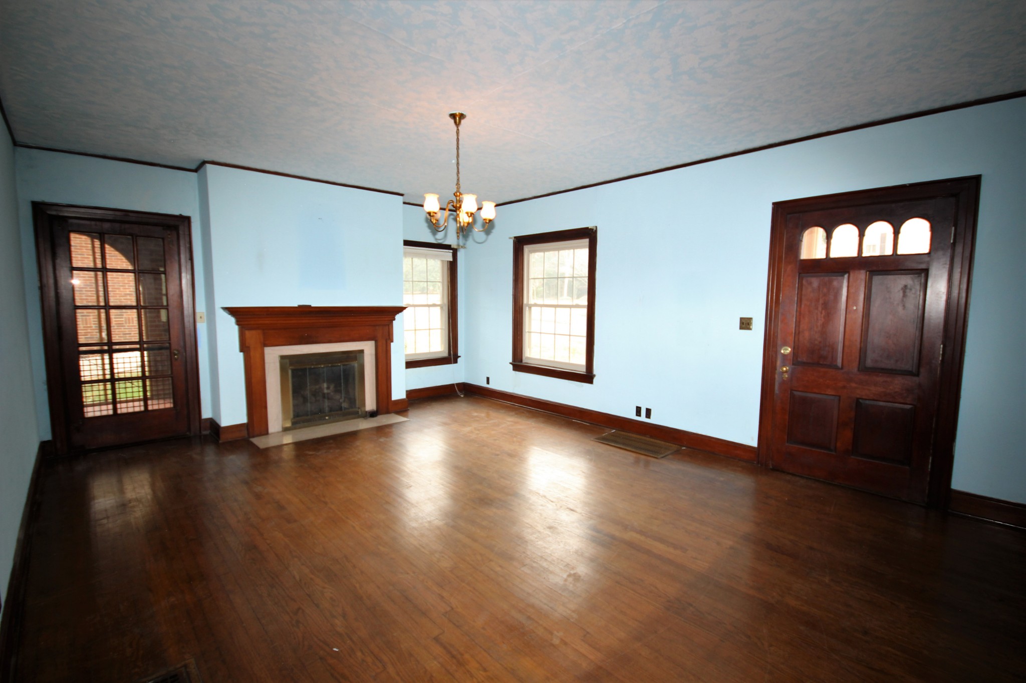 310 North Garner Street Springfield, TN 37172 - Photo 7 of 22 an empty room with wooden floor fireplace and windows