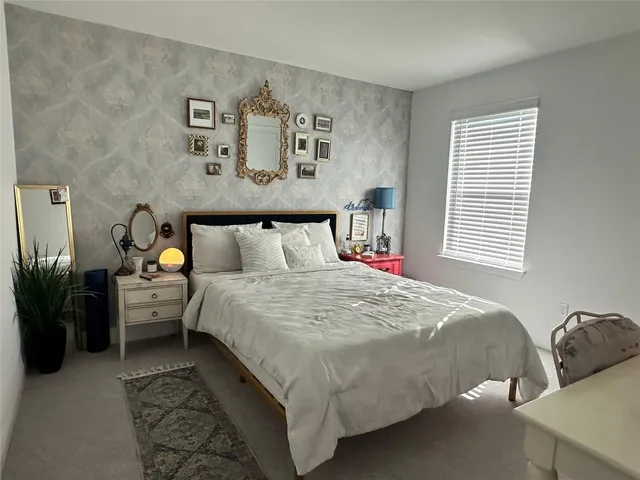 a bedroom with a bed and a painting on the wall