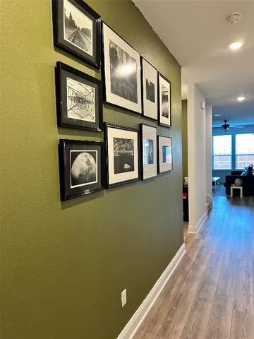 a view of a hallway with wooden floor and a cabinet