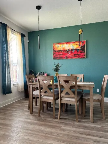 a dining room with furniture a chandelier and wooden floor