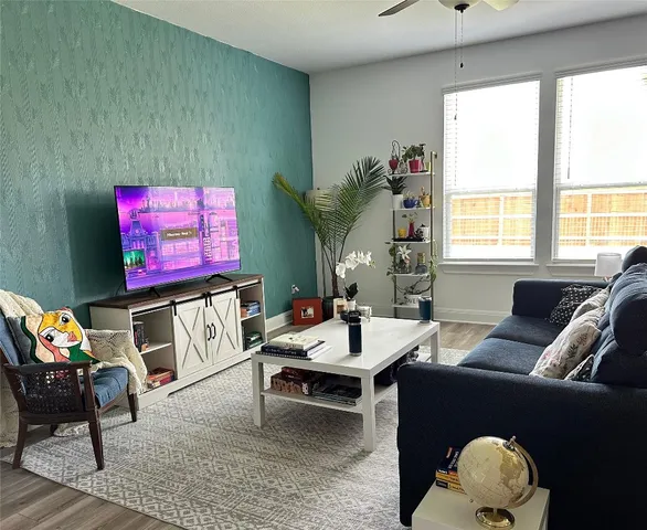 a living room with furniture a rug and a floor to ceiling window