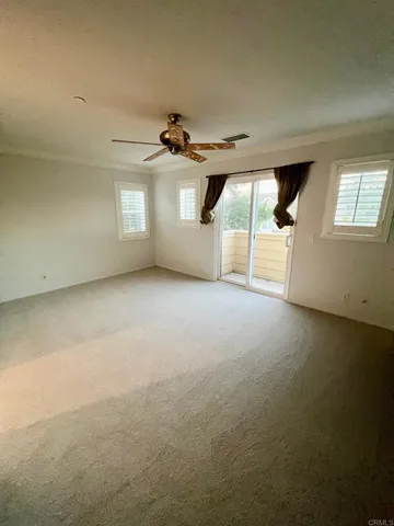 an empty room with windows and ceiling fan