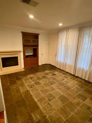 a view of an empty room with a fireplace and a window