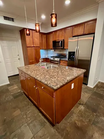 a kitchen with stainless steel appliances granite countertop a refrigerator a sink and a stove