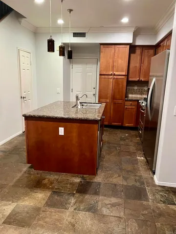 a kitchen with stainless steel appliances granite countertop a sink a stove a refrigerator and a refrigerator