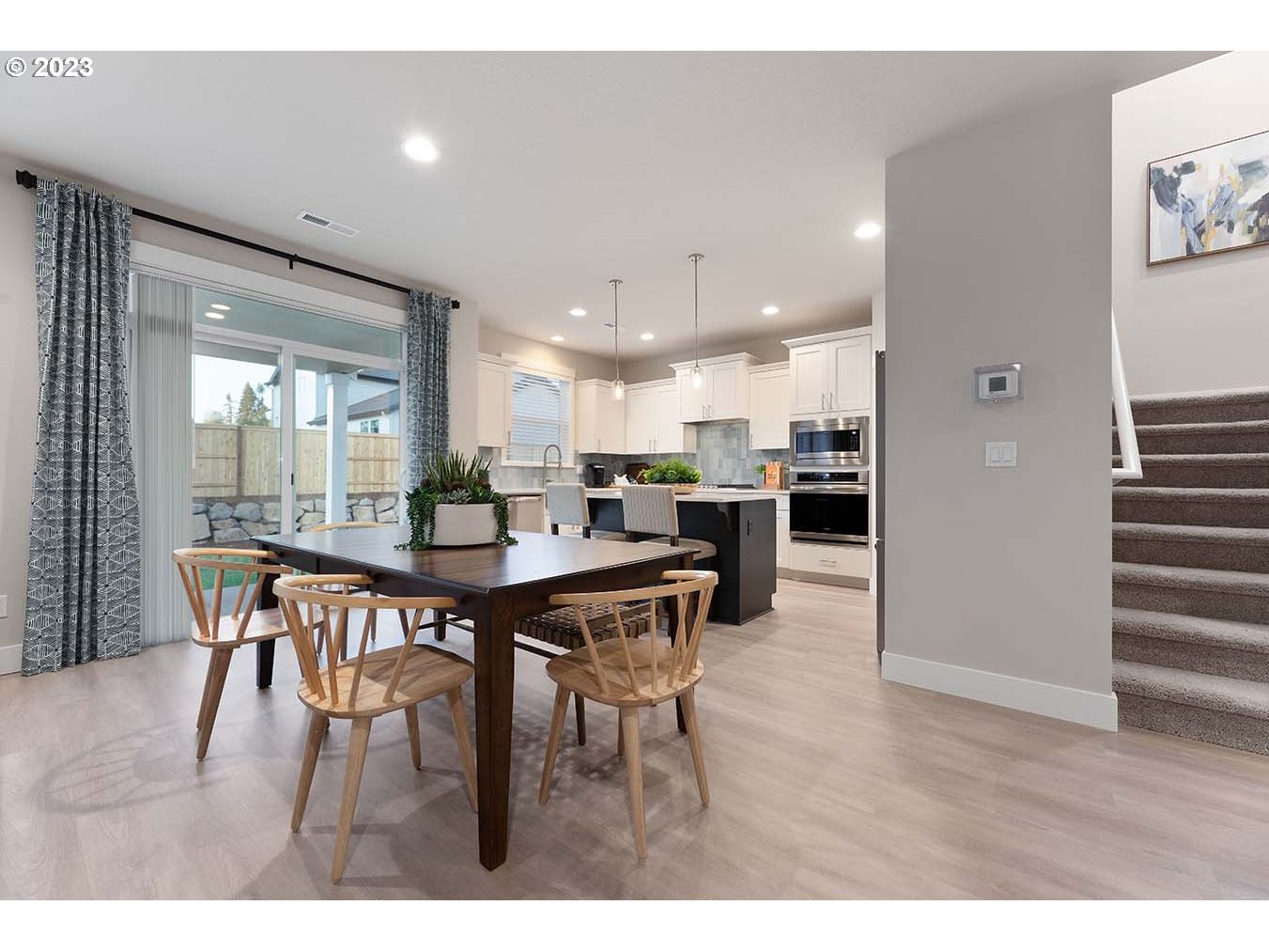 302 North 89th Loop Ridgefield, WA 98642 - Photo 5 of 29 a open kitchen with stainless steel appliances kitchen island granite countertop a dining table chairs and white refrigerator