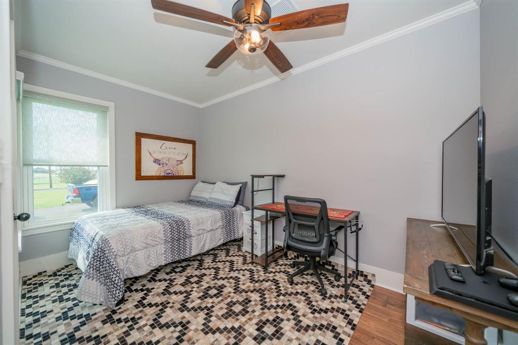 1901 Byrd Road Jacksonville, TX 75766 - Photo 23 of 40 a bedroom with a bed and a chandelier