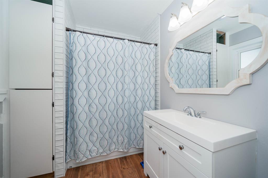 1901 Byrd Road Jacksonville, TX 75766 - Photo 27 of 40 a bathroom with a sink a mirror and a shower curtain