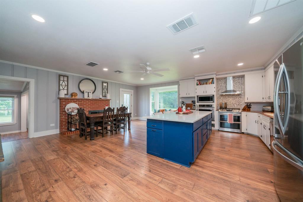 1901 Byrd Road Jacksonville, TX 75766 - Photo 9 of 40 a kitchen with stainless steel appliances kitchen island granite countertop a table chairs sink and cabinets