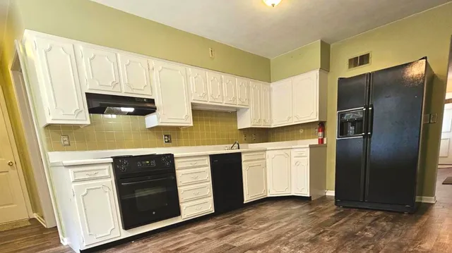 a kitchen with a refrigerator sink and cabinets