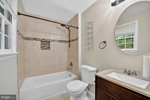 a bathroom with a granite countertop sink toilet a mirror and shower