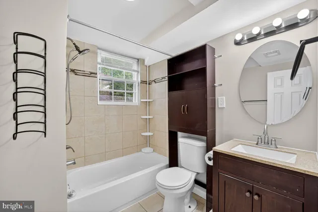 a bathroom with a bathtub sink mirror vanity and toilet