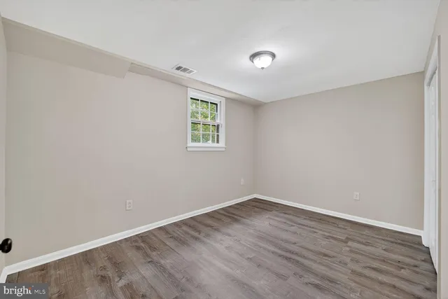 a view of a room that has wooden floor and window
