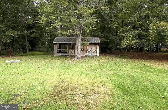 a view of a house with backyard and trees