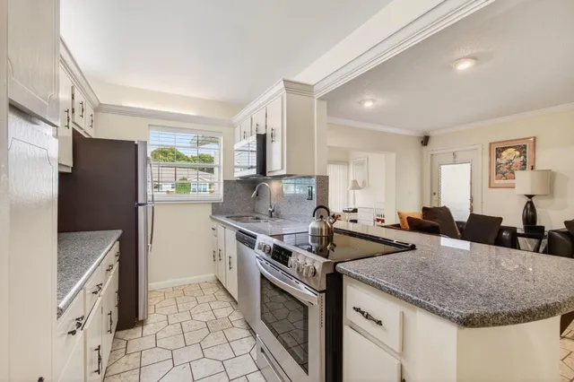 a kitchen with stainless steel appliances granite countertop a sink stove and refrigerator
