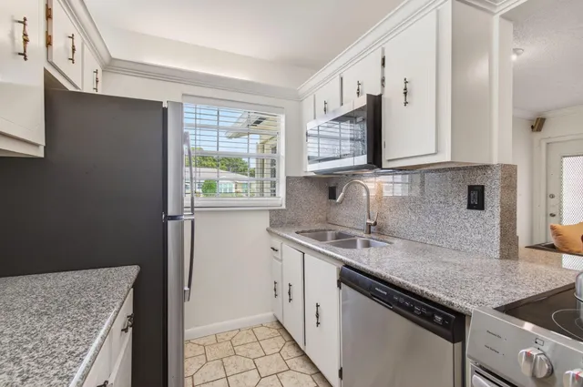 a kitchen with a sink stove and cabinets