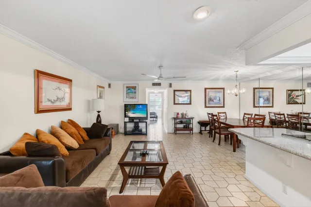a living room with furniture kitchen view and a window