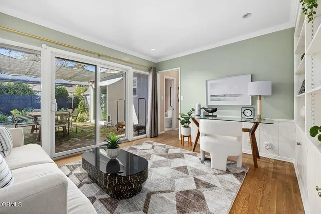 a living room with furniture a large window and a wooden floor