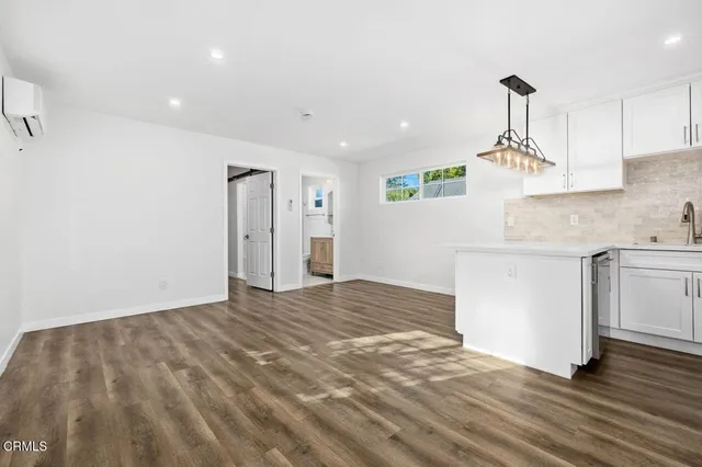 a kitchen with kitchen island white cabinets and wooden floor