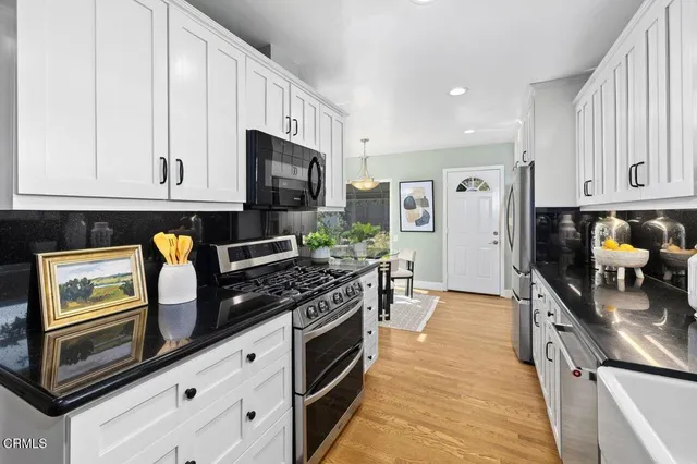 a kitchen with stainless steel appliances granite countertop a stove a sink and a microwave