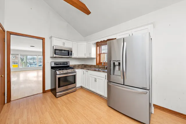 a kitchen with stainless steel appliances a refrigerator sink and microwave