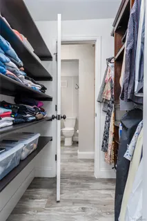 a view of walk in closet with clothes and shoes
