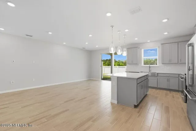 a large kitchen with a lot of counter space and a wooden floor