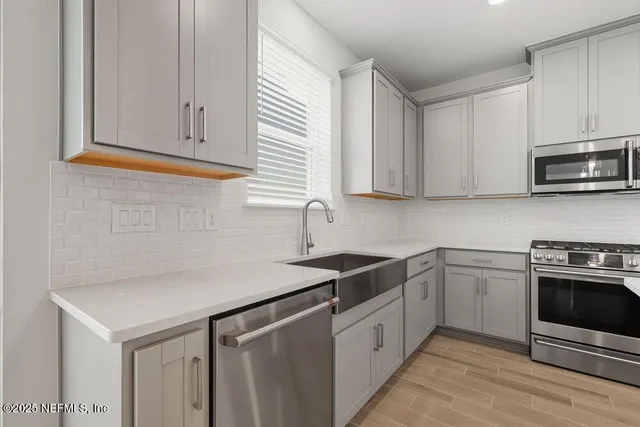 a kitchen with granite countertop white cabinets stainless steel appliances and a sink