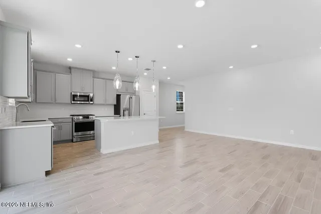 a view of kitchen with kitchen island sink stainless steel appliances and cabinets