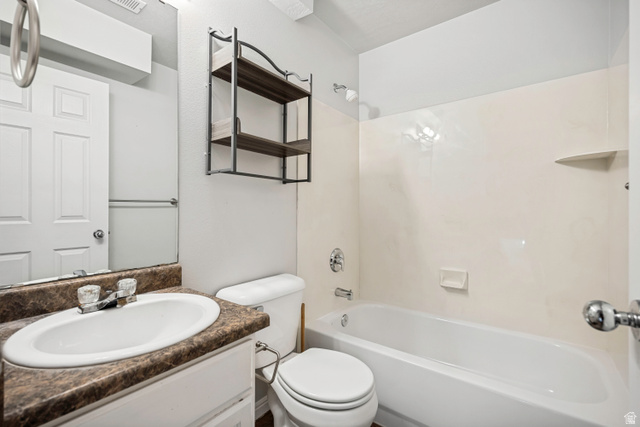 5529 Ridge Hollow Way Kearns, UT 84118 - Photo 11 of 23 Bathroom featuring a white vanity with an oval sink, a patterned countertop, and a built-in tub with a shower