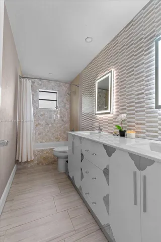 a bathroom with a toilet a sink a tub and mirror