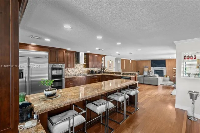 a large kitchen with a large counter top stainless steel appliances and a window