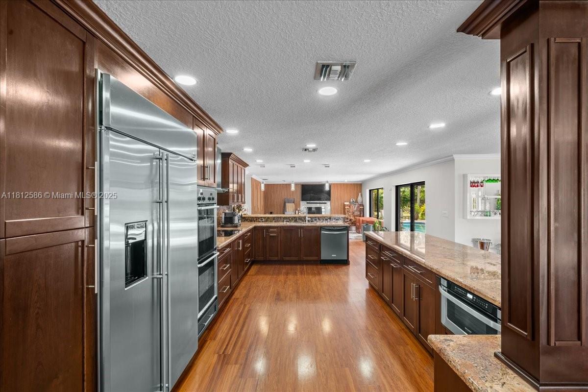 3030 Southwest 117th Avenue Davie, FL 33330 - Photo 7 of 47 a large kitchen with a large counter top stainless steel appliances and a window