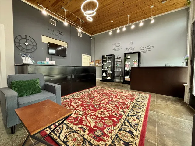 a living room with stainless steel appliances kitchen island granite countertop furniture a rug and a view of kitchen