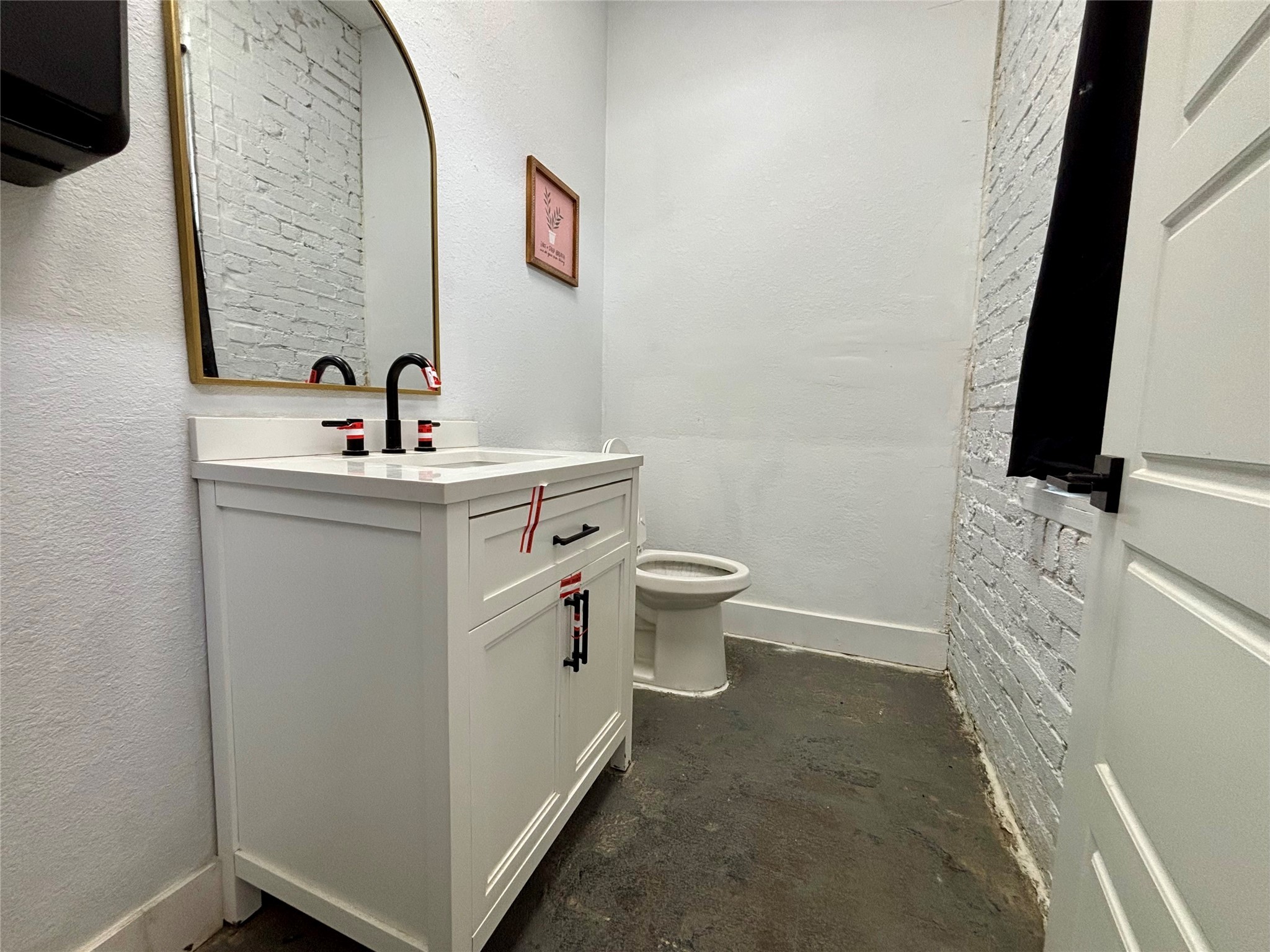 129 South Fulton Street Wharton, TX 77488 - Photo 8 of 15 a bathroom with a toilet sink and mirror