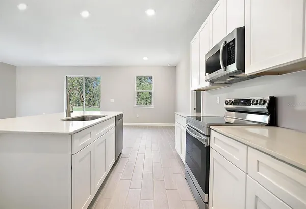 a kitchen with stainless steel appliances granite countertop a sink and a stove