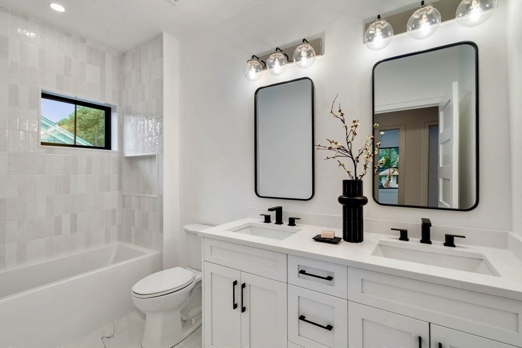 71 Cloverdale Road, Unit 1 Newton, MA 02461 - Photo 19 of 32 a bathroom with a double vanity sink mirror and bathtub