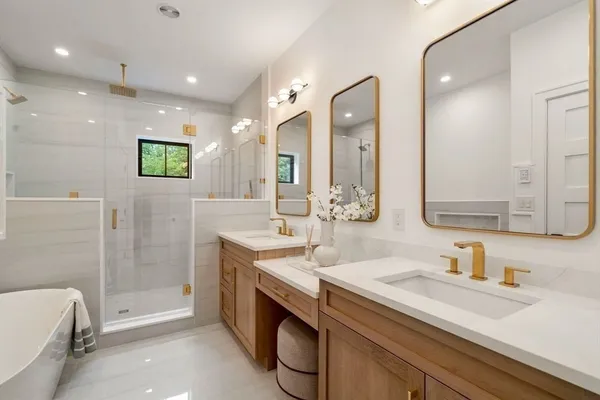 a bathroom with a double vanity sink mirror and bathtub