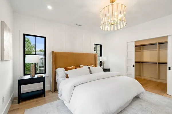 a bedroom with a large bed and a chandelier