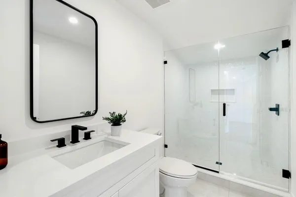 a bathroom with a sink a toilet and shower