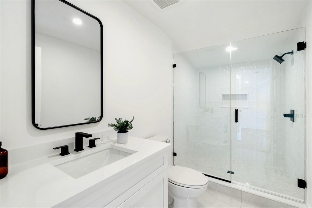 71 Cloverdale Road, Unit 1 Newton, MA 02461 - Photo 27 of 32 a bathroom with a sink a toilet and shower