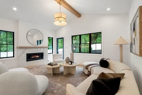 a living room with furniture a fireplace and a large window