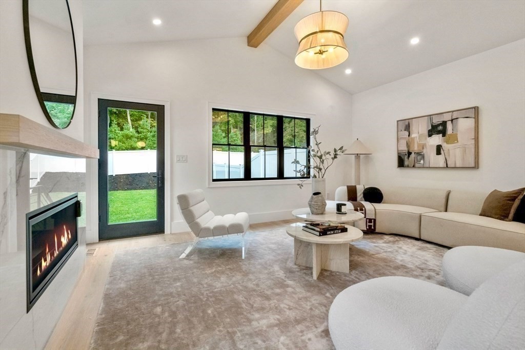 71 Cloverdale Road, Unit 1 Newton, MA 02461 - Photo 30 of 32 a living room with furniture a fireplace and a floor to ceiling window