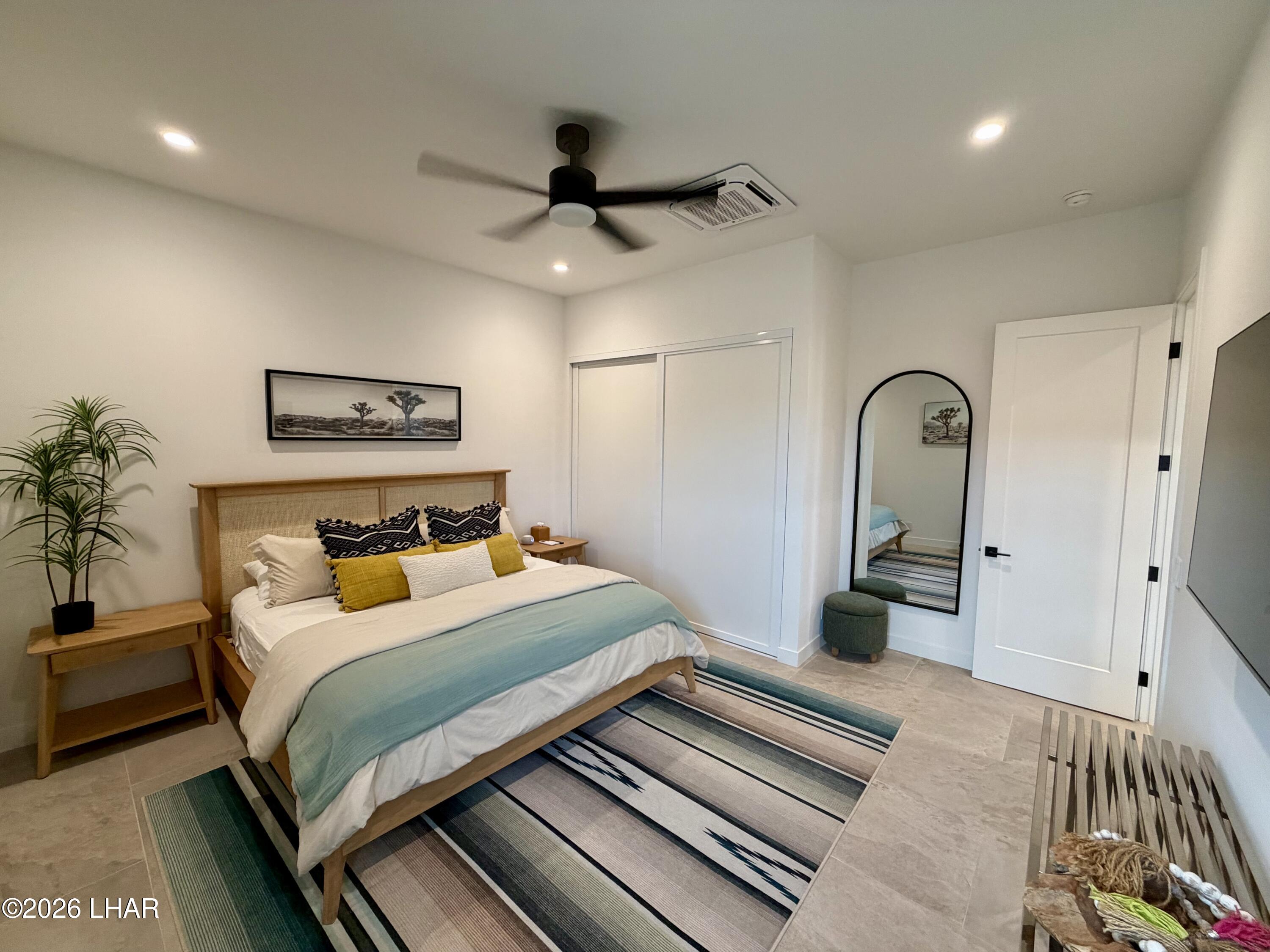 48963 Riviera Place Ehrenberg, AZ 85334 - Photo 32 of 58 a bedroom with a large bed and a chandelier