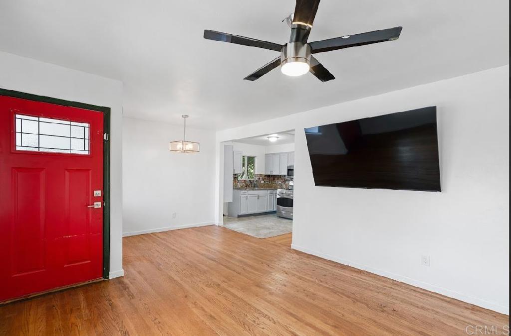 3964 Delta Street San Diego, CA 92113 - Photo 3 of 42 a view of a livingroom with a flat screen tv wooden floor and a ceiling fan