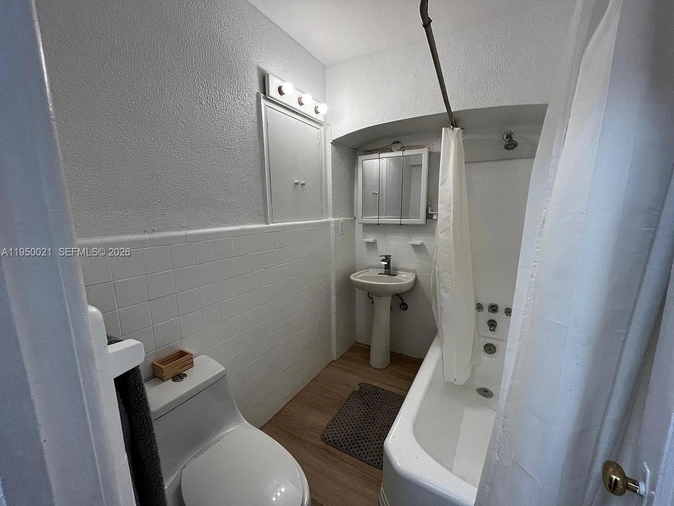 2049 Southwest 60th Court, Unit 1 Miami, FL 33155 - Photo 11 of 16 a white toilet sitting next to a bathroom sink