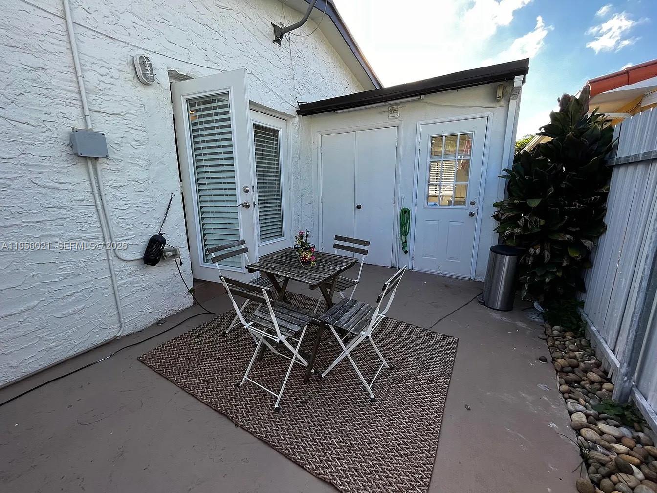 2049 Southwest 60th Court, Unit 1 Miami, FL 33155 - Photo 12 of 16 a patio with table and chairs and potted plants