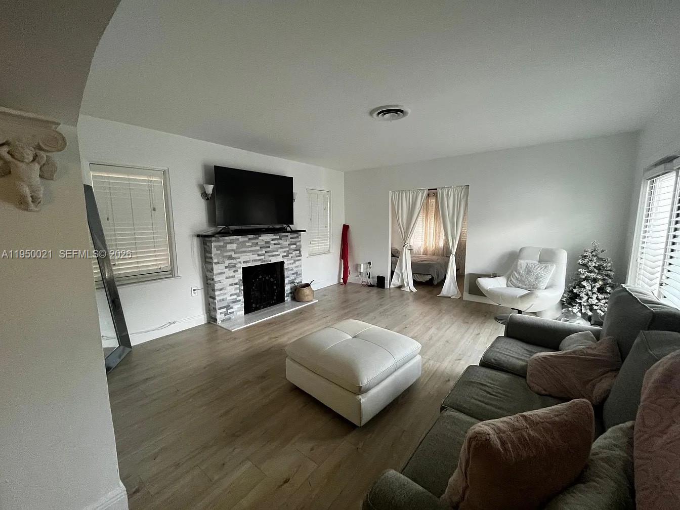 2049 Southwest 60th Court, Unit 1 Miami, FL 33155 - Photo 14 of 16 a living room with furniture flat screen tv and a fireplace