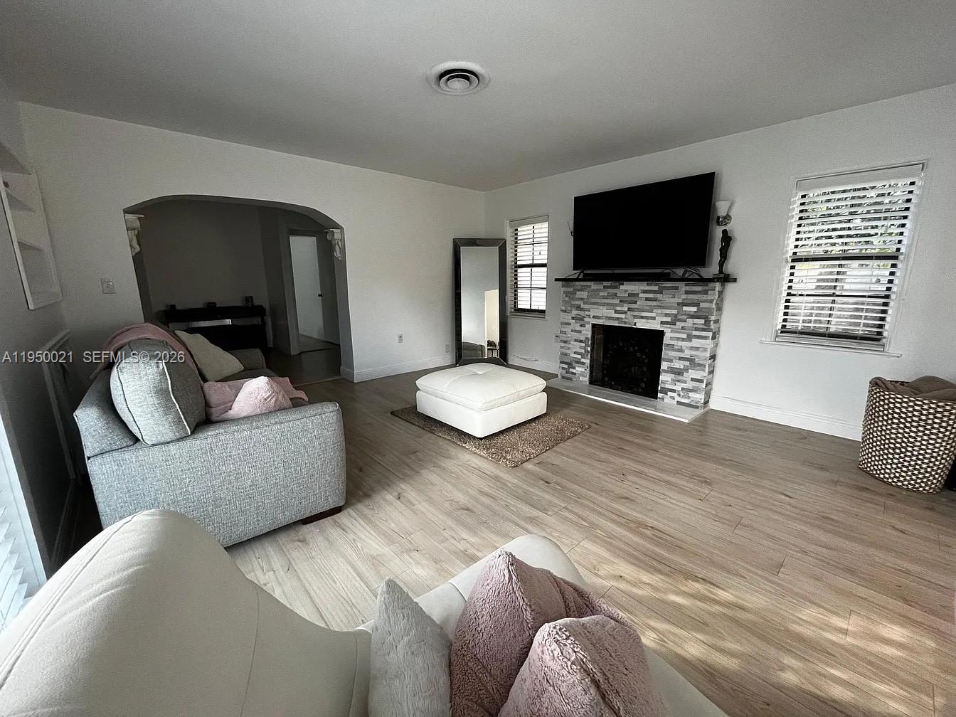 2049 Southwest 60th Court, Unit 1 Miami, FL 33155 - Photo 2 of 16 a living room with furniture a flat screen tv and a fireplace