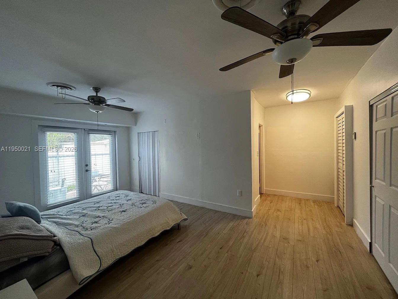 2049 Southwest 60th Court, Unit 1 Miami, FL 33155 - Photo 4 of 16 a bedroom with a large bed and wooden floor